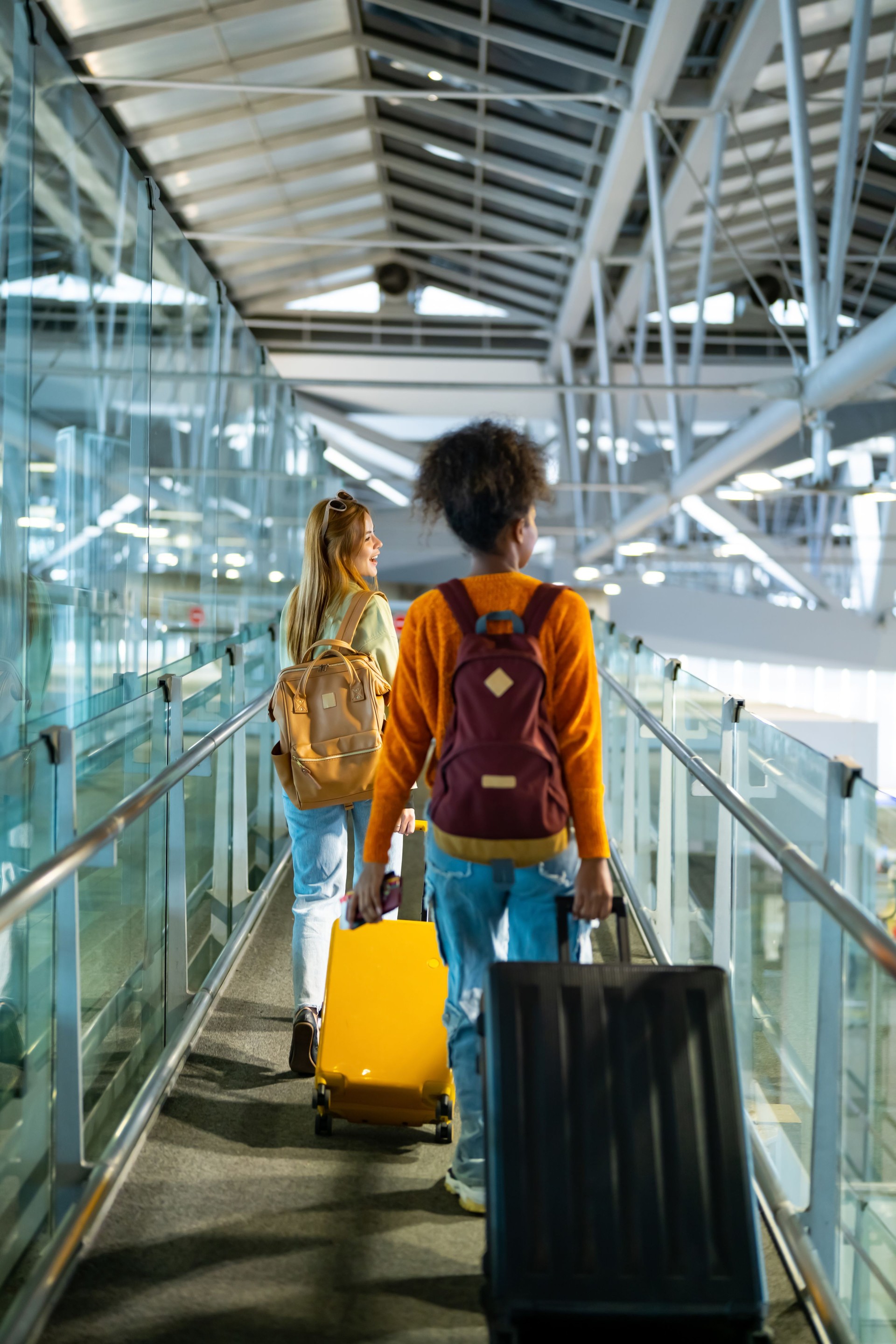 Deux amies marchant ensemble dans le terminal de l’aéroport.