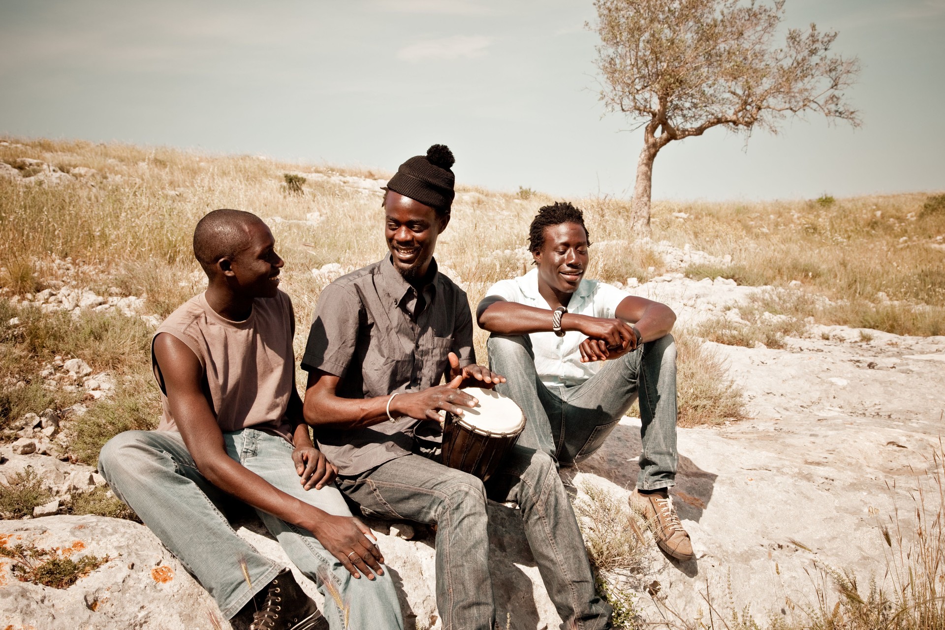 Trois homme africain jouant Djembé dans la Prairie
